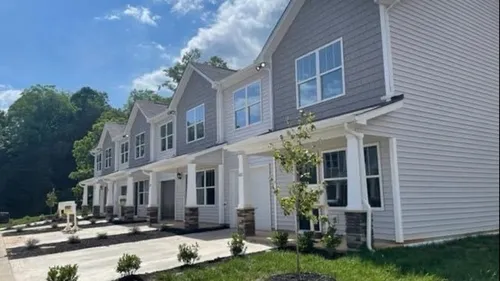 Exterior of community with green grass and driveways in the daytime