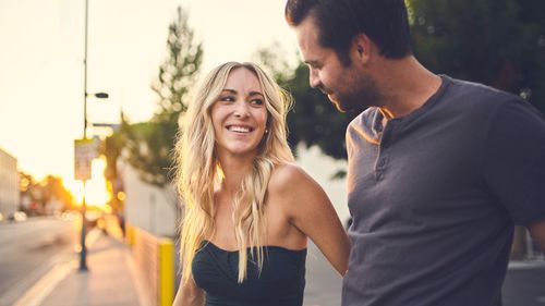 couple smiling at each other walking outside