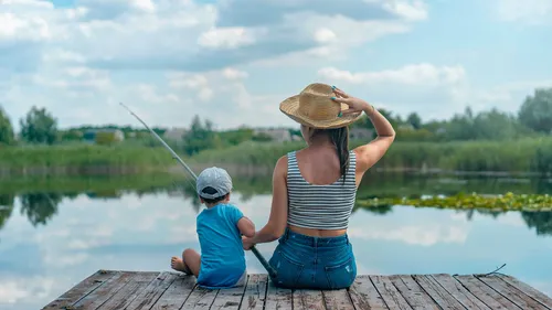woman fishing at a dock with a kid