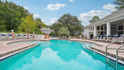 Inviting outdoor pool area with sun-loungers and lush greenery, perfect for relaxation and leisure.