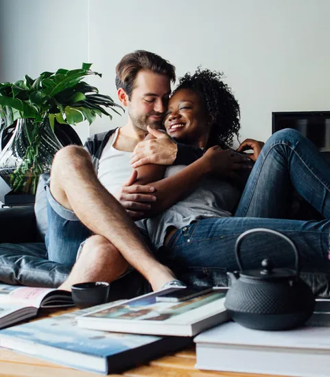 man and woman hugging and cuddling on couch in living room