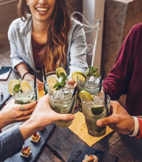 group of people cheersing at dining table in restaurant