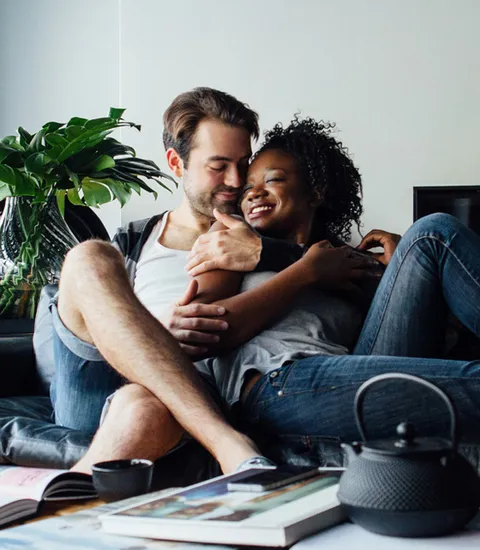 woman and man cuddling on couch in living area of home