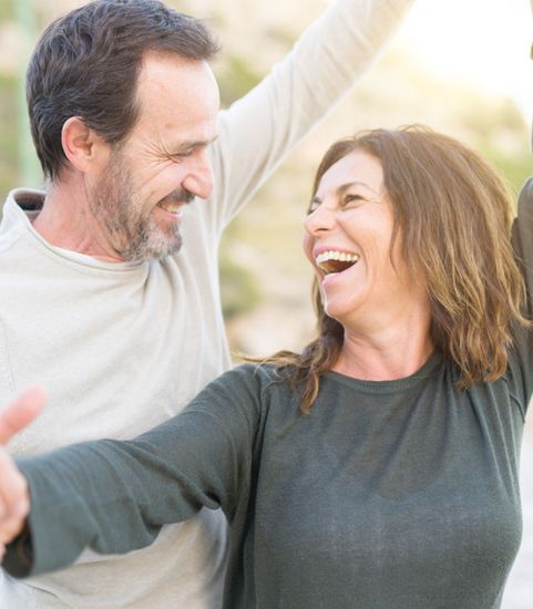 man and woman dancing and smiling at each other in daytime