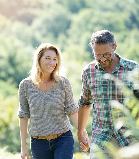 woman and man holding hands walking outdoors