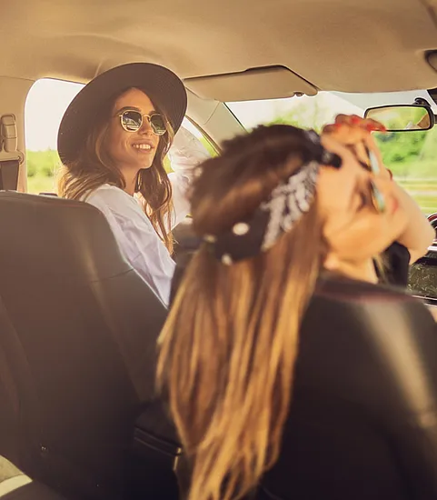 two hipster women riding in a car