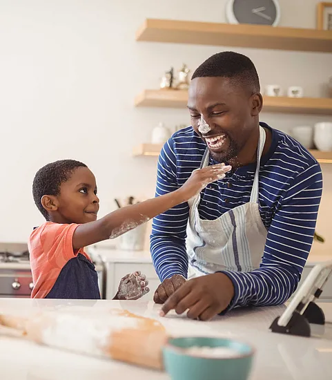 father and son playing together in a kitchen
