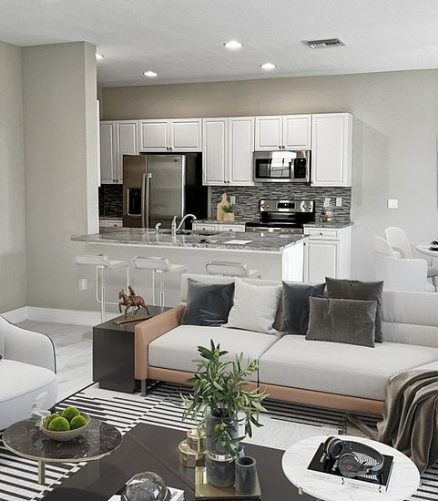 Modern open-concept living room and kitchen with stylish decor, sleek appliances, and a cozy dining area.