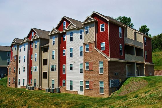 Pictured is the front of one of the buildings located within our community. Standing 4 stories high, showcasing brick designs on the right-hand side, and moving into vinyl siding, to which each building possesses