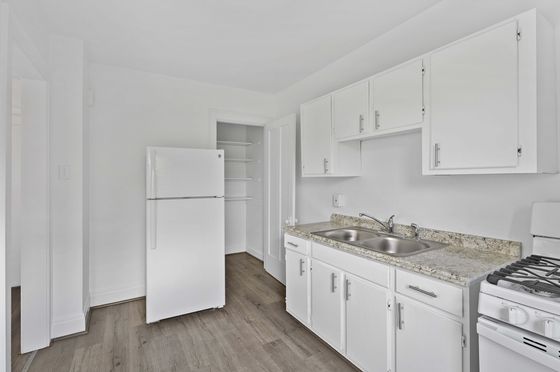 Bright and modern kitchen with sleek white cabinets, granite countertops, and elegant hardwood floors.