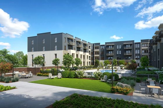 Beautiful apartment complex surrounded by lush landscaping and a sparkling pool.