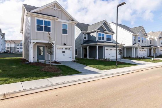 Charming modern homes with attractive facades and manicured lawns in a serene suburban neighborhood.