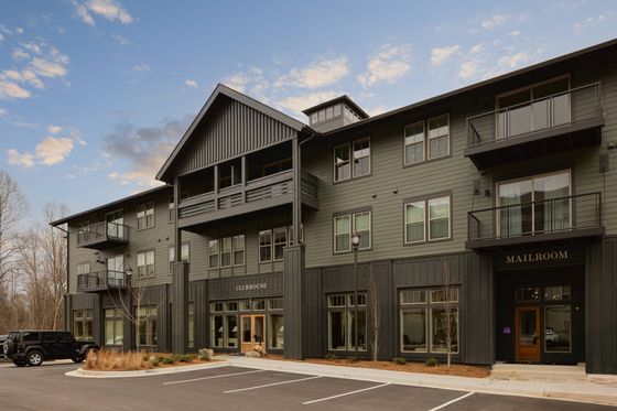 Contemporary apartment building with balconies, showcasing modern design and serene surroundings.