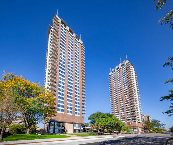 Impressive high-rise community with contemporary architecture surrounded by lush greenery and urban landscape.