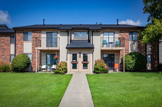 Charming two-story apartment building with spacious balconies and vibrant landscaping.