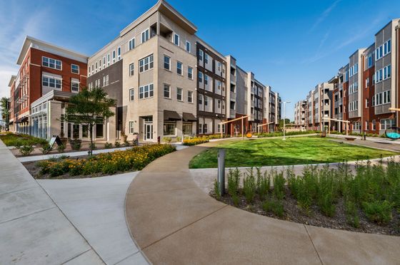 Charming modern apartment community with landscaped paths, vibrant greenery, and elegant architecture.