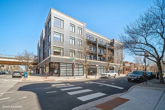 Modern urban apartment building with sleek design on a bustling city street, offering convenient access to local amenities.
