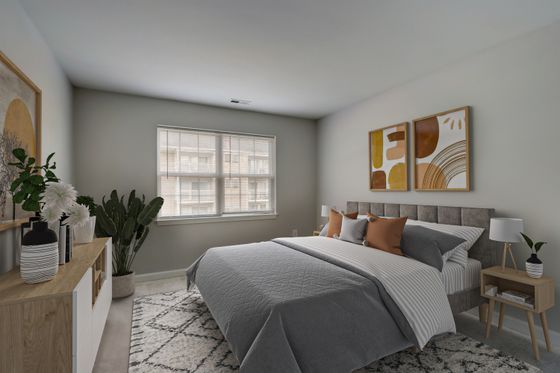 Stylish bedroom with gray bedding, abstract wall art, and potted plants.