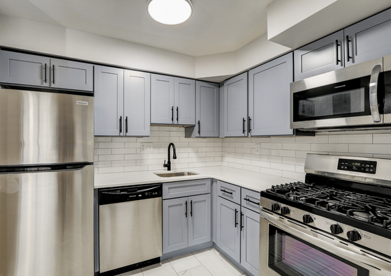Contemporary kitchen with sleek stainless steel appliances and light blue cabinets.