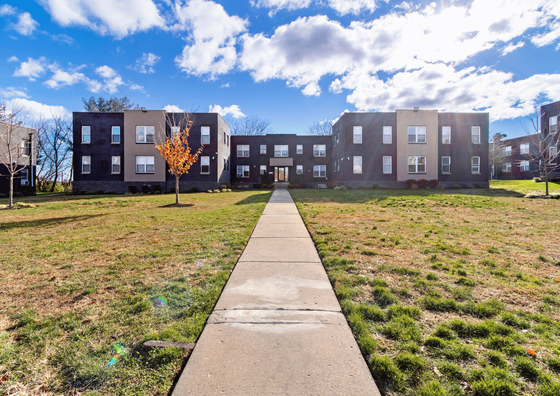Inviting exterior view of a contemporary apartment complex under a bright blue sky.