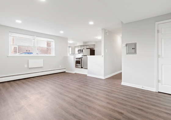 Bright open-concept living space featuring sleek hardwood floors and a modern kitchen.