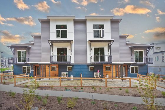Elegant facade of modern townhomes featuring large windows and balconies.