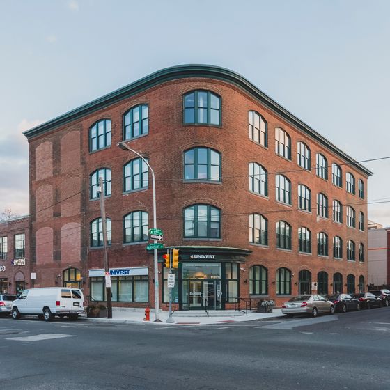 Charming historic brick building with large arched windows, ideal for urban living and business in a vibrant city setting.