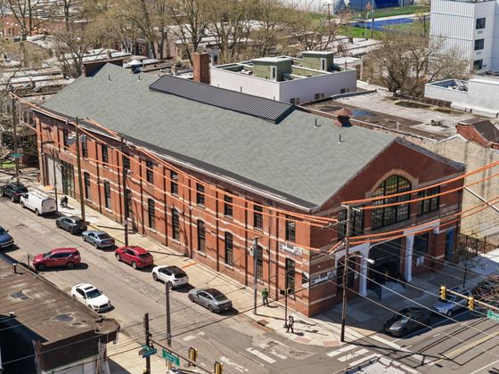 Charming historic brick building with large arched windows, situated on a lively street corner, ideal for urban living.