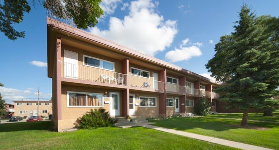 Beautiful two-story townhome building with a well-maintained garden and spacious balconies.