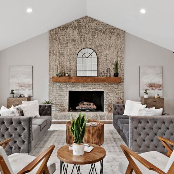 Elegantly designed living room with a rustic brick fireplace, plush tufted sofas, and modern accents.