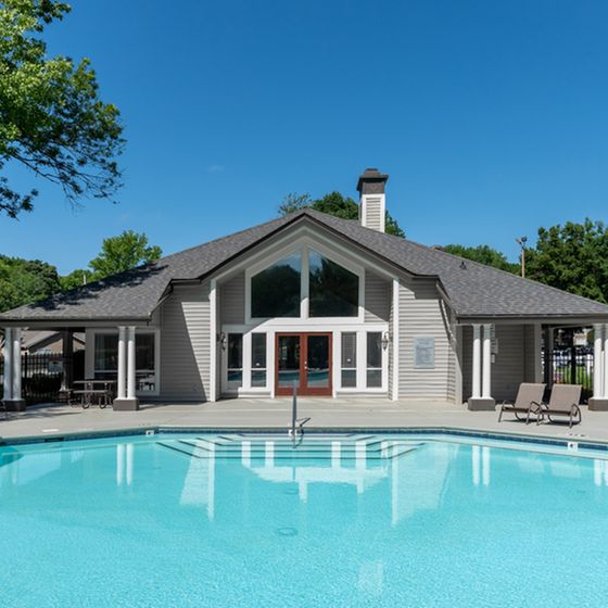 Luxurious community clubhouse with a sparkling pool, perfect for relaxation and social gatherings.