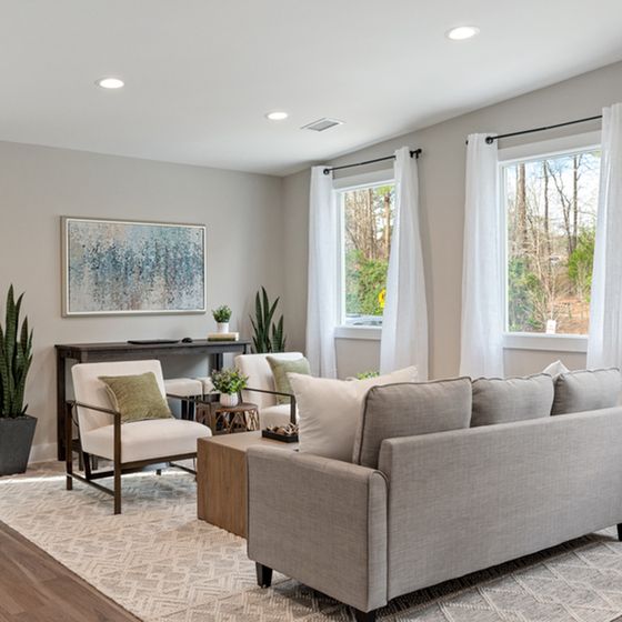 Bright, modern living room with inviting neutral tones, sleek furnishings, and large windows highlighting serene outdoor views.