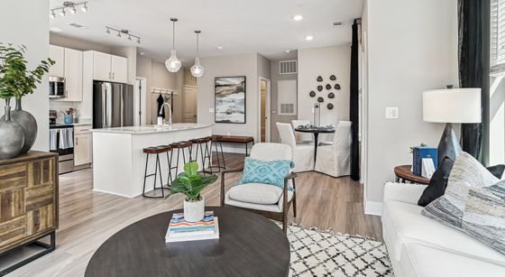 Chic open-concept living space with a modern kitchen, cozy seating area, and elegant dining nook, featuring stylish decor and abundant natural light.