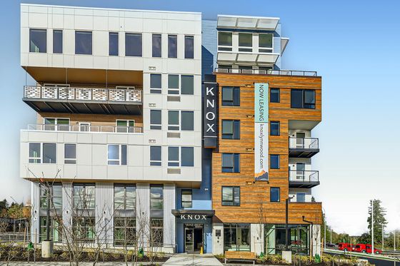 Contemporary apartment building with stylish balconies, modern architecture, and prominent leasing banner.