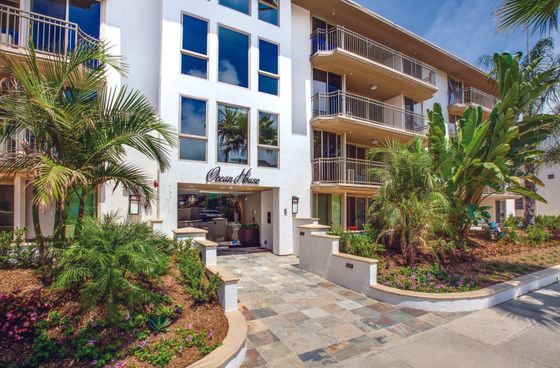 Elegant exterior of Ocean House featuring lush tropical landscaping, large windows, and inviting balconies.