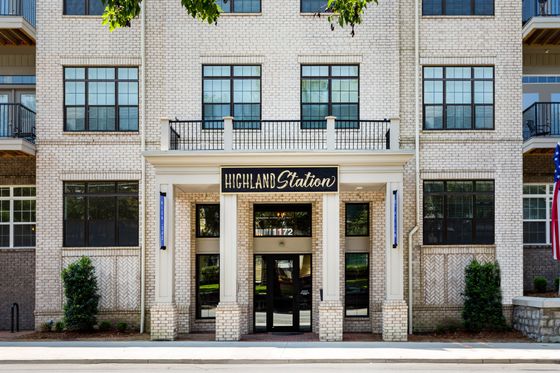 Charming brick facade of Highland Station apartments with modern architecture and elegant entrance.