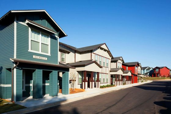 Charming row of modern townhouse-style apartments with colorful facades and clean, inviting streetscape.