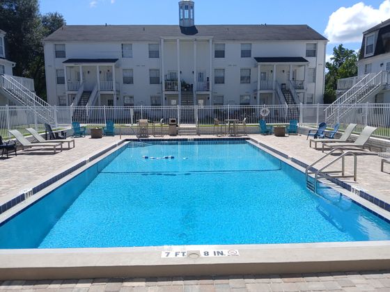 Inviting communal swimming pool surrounded by sun loungers and charming apartment buildings, perfect for relaxation and leisure.