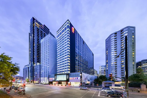Stunning urban skyline featuring towering modern high-rise buildings with illuminated windows at dusk.