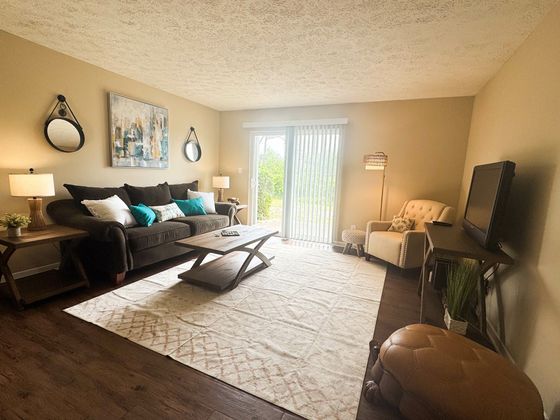 Inviting living room with cozy brown sofa, elegant decor, and large window providing natural light.