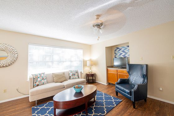 Bright and inviting living room featuring elegant white sofa, stylish navy armchair, and modern decor, perfect for relaxation.