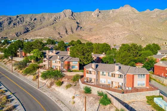 Charming hillside residential area with modern apartments surrounded by lush greenery and breathtaking mountain views.