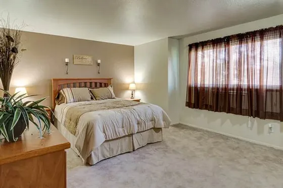 Inviting bedroom with cozy lighting, elegant decor, and a large window for natural light.