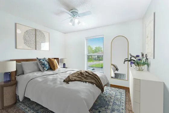 Bright, modern bedroom with a king-sized bed, stylish decor, and a large window offering a pleasant garden view.