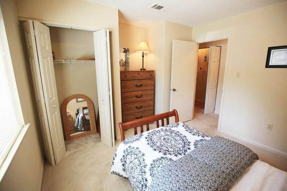 Cozy bedroom with elegant wooden furniture, soft lighting, and a large closet, ideal for comfort and style.