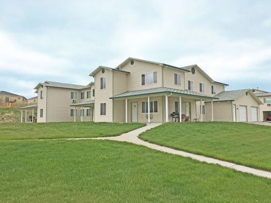 Charming suburban complex with modern two-story townhouses, lush green lawns, and peaceful surroundings.