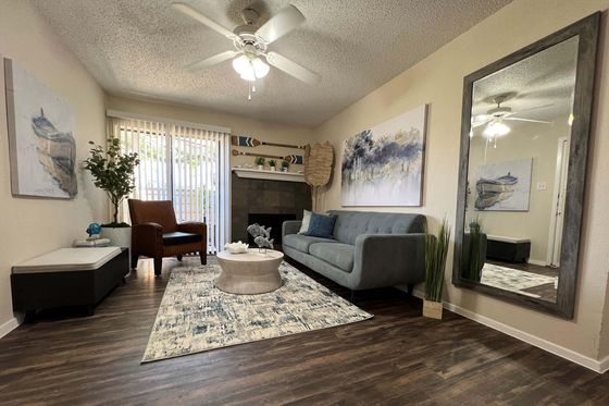 Inviting living room with modern decor, cozy sofa, elegant artwork, and large mirror complementing the serene atmosphere.