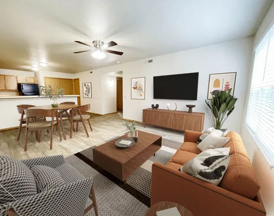 Modern open-plan living room and dining area with stylish decor, featuring a large wall-mounted TV, elegant wooden furniture, and warm natural lighting.