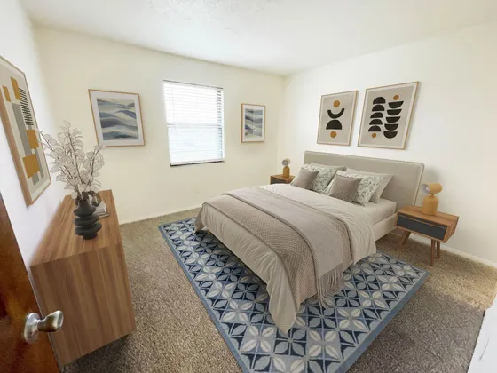 Charming bedroom featuring a cozy bed with stylish pillows, elegant artwork, and modern wooden furniture in a bright, sunlit space.