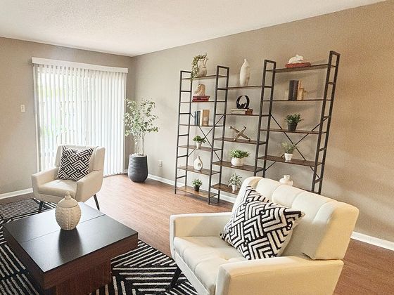 Inviting living room with modern decor, cozy seating, and stylish shelving in an elegant apartment.
